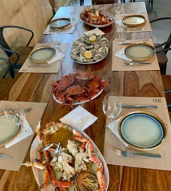 Mesa preparada con marisco y vino blanco